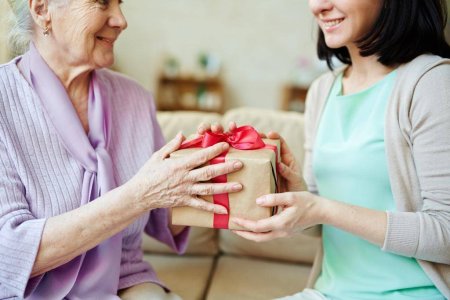 Женщина дарит подарок матери